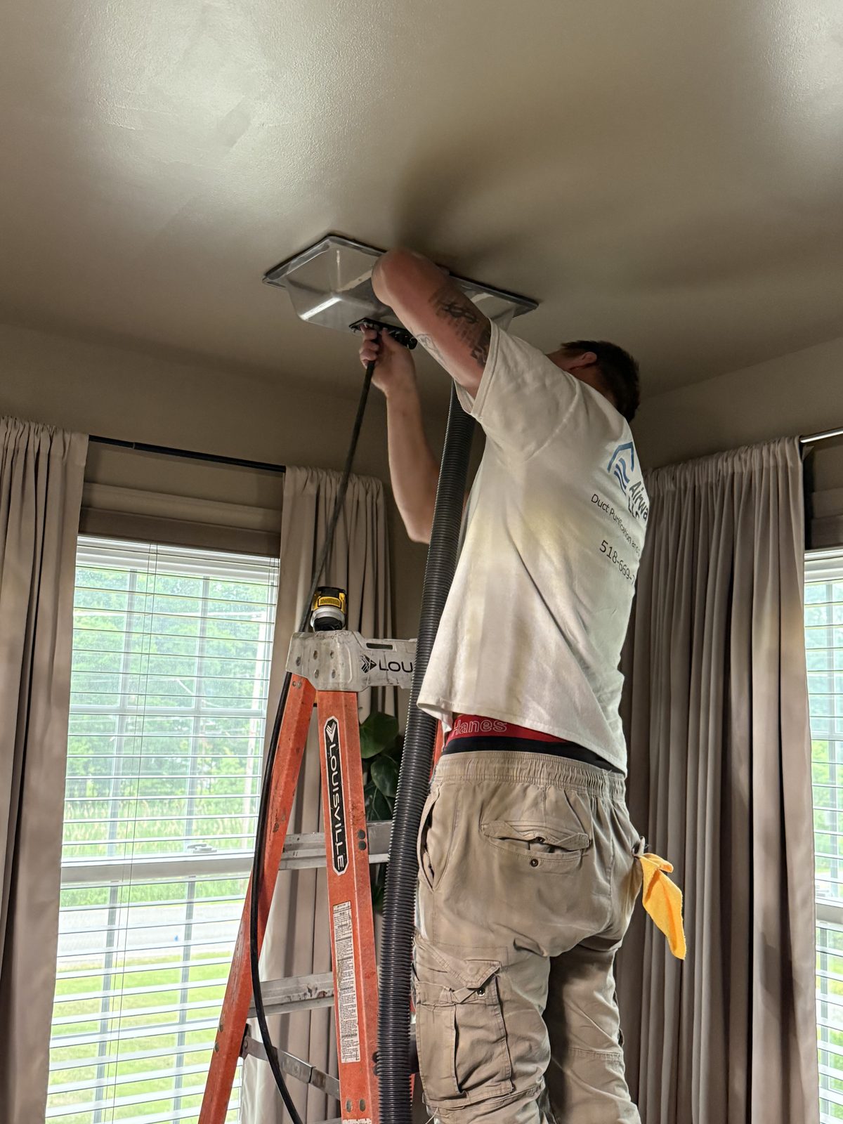 Pure Airways technician cleaning a ceiling vent